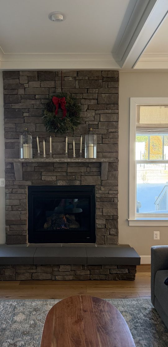 Her stone fireplace as it is, with a wreath and candles on the mantel